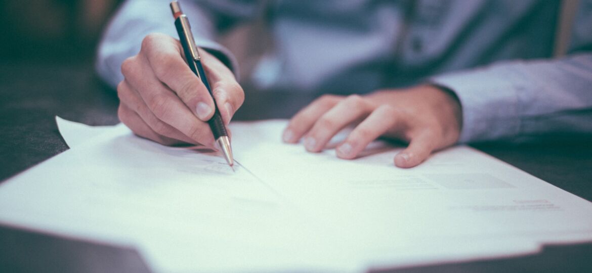 man signing documents