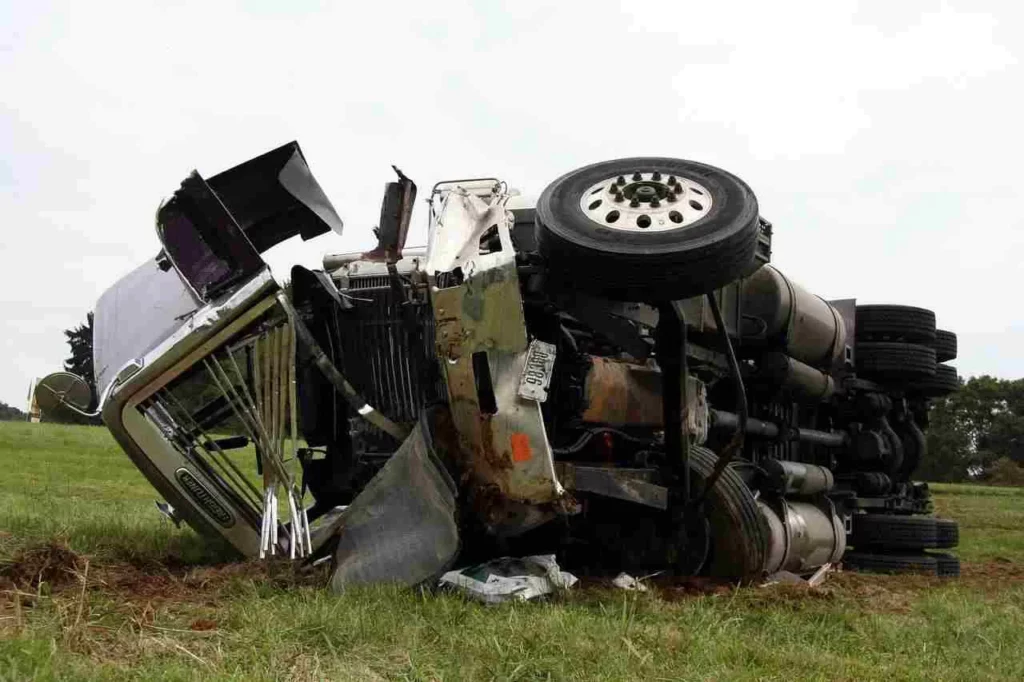 damaged truck lying in the grass after a collision