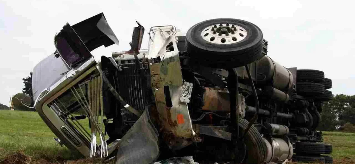 damaged truck lying in the grass after a collision