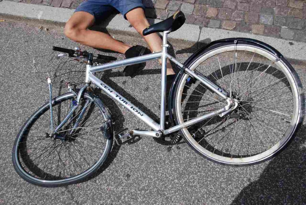 man lying on the ground injured after a bicycle accident