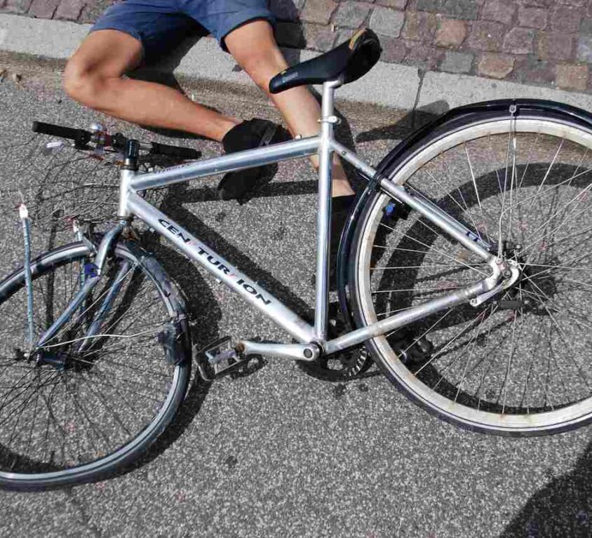 man lying on the ground injured after a bicycle accident