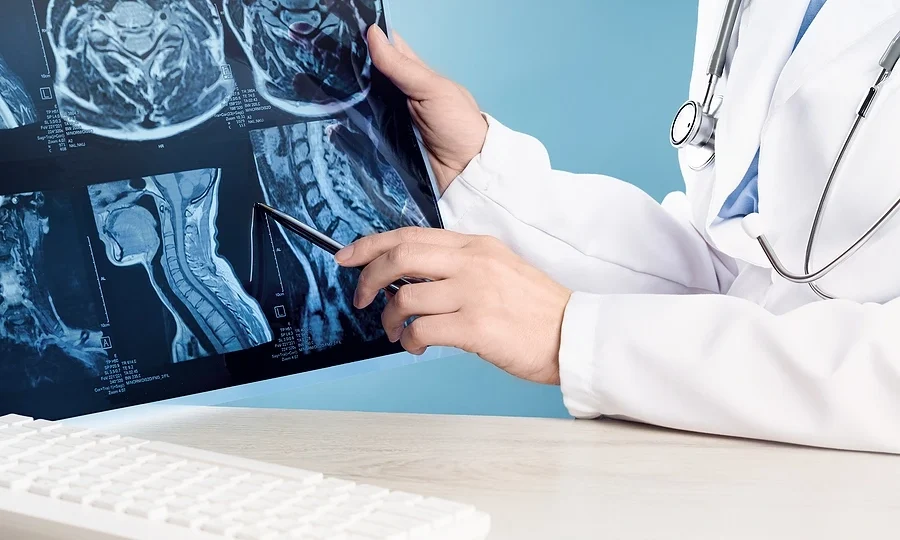 Doctor pointing at brain and neck x-rays